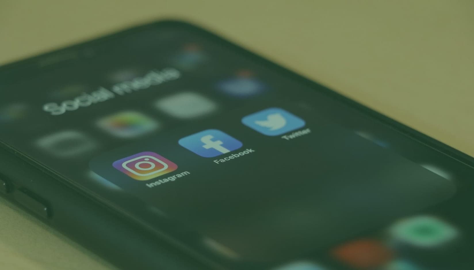 cell phone with social media icons on the screen - social media marketing for coworking space promotion