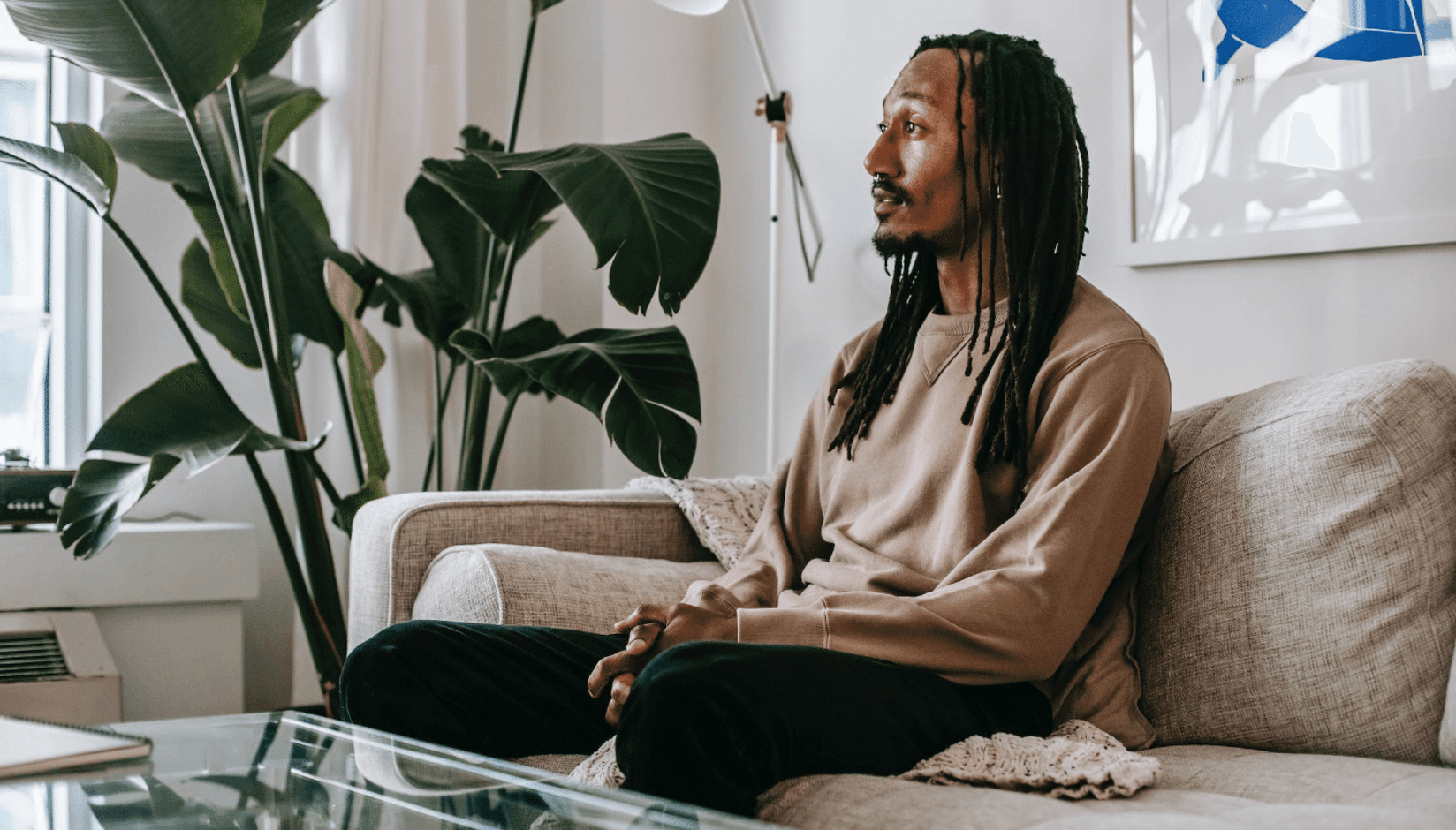 Coworking space member sitting in the lounge surrounded by green plants 