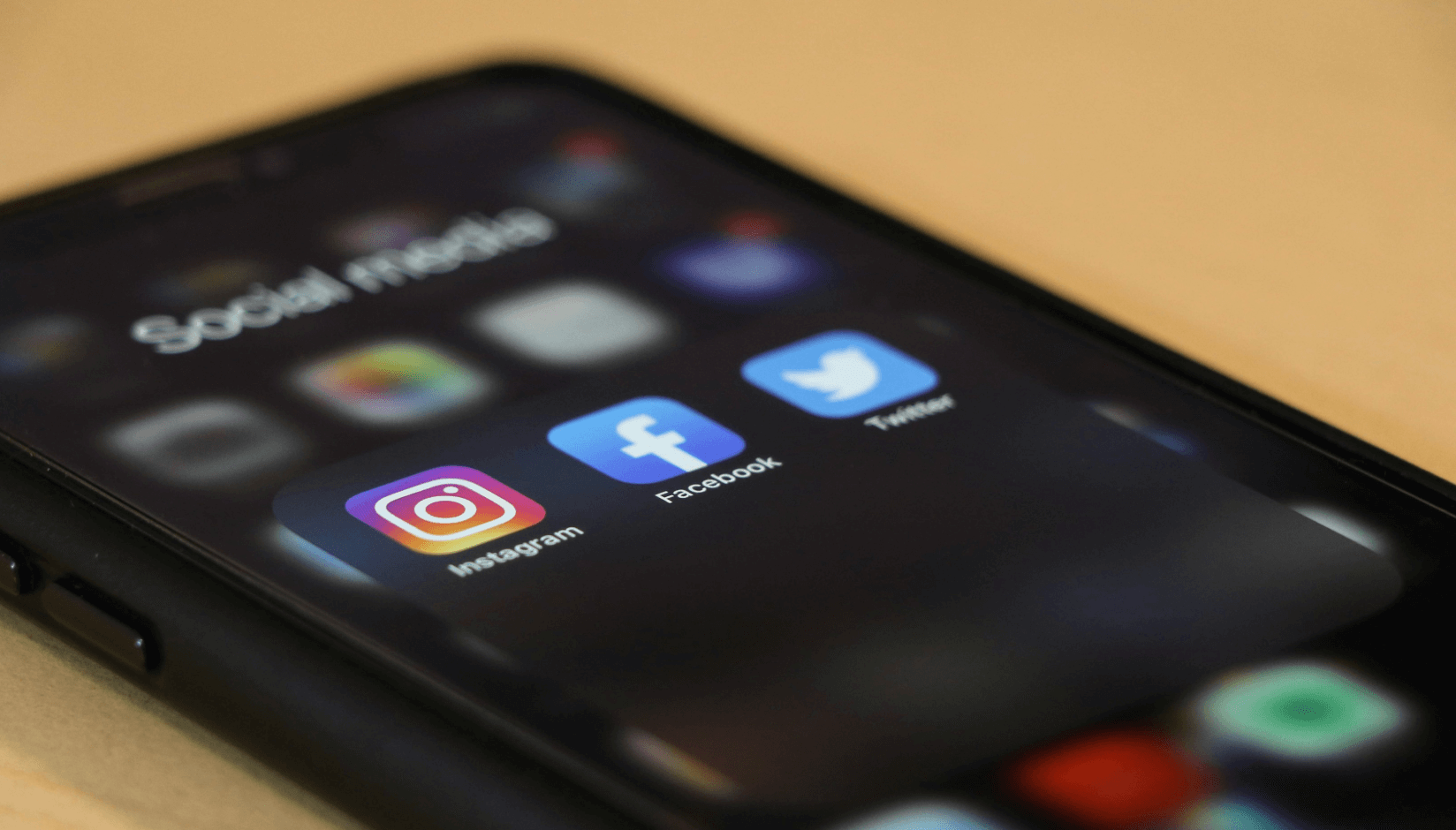 cell phone with social media icons on the screen - social media marketing for coworking space promotion