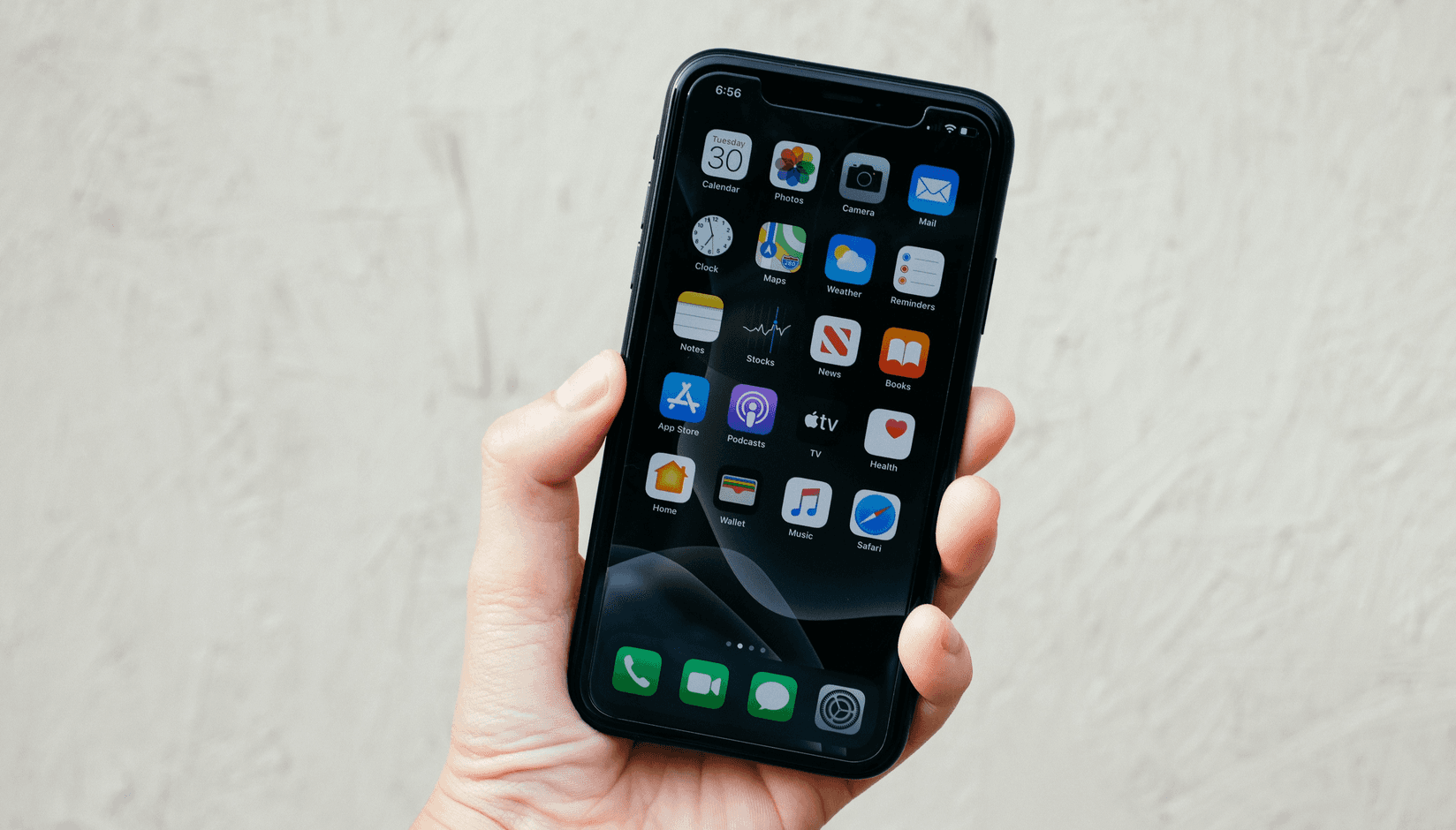 coworking space member at the desk looking at the apps on his smartphone