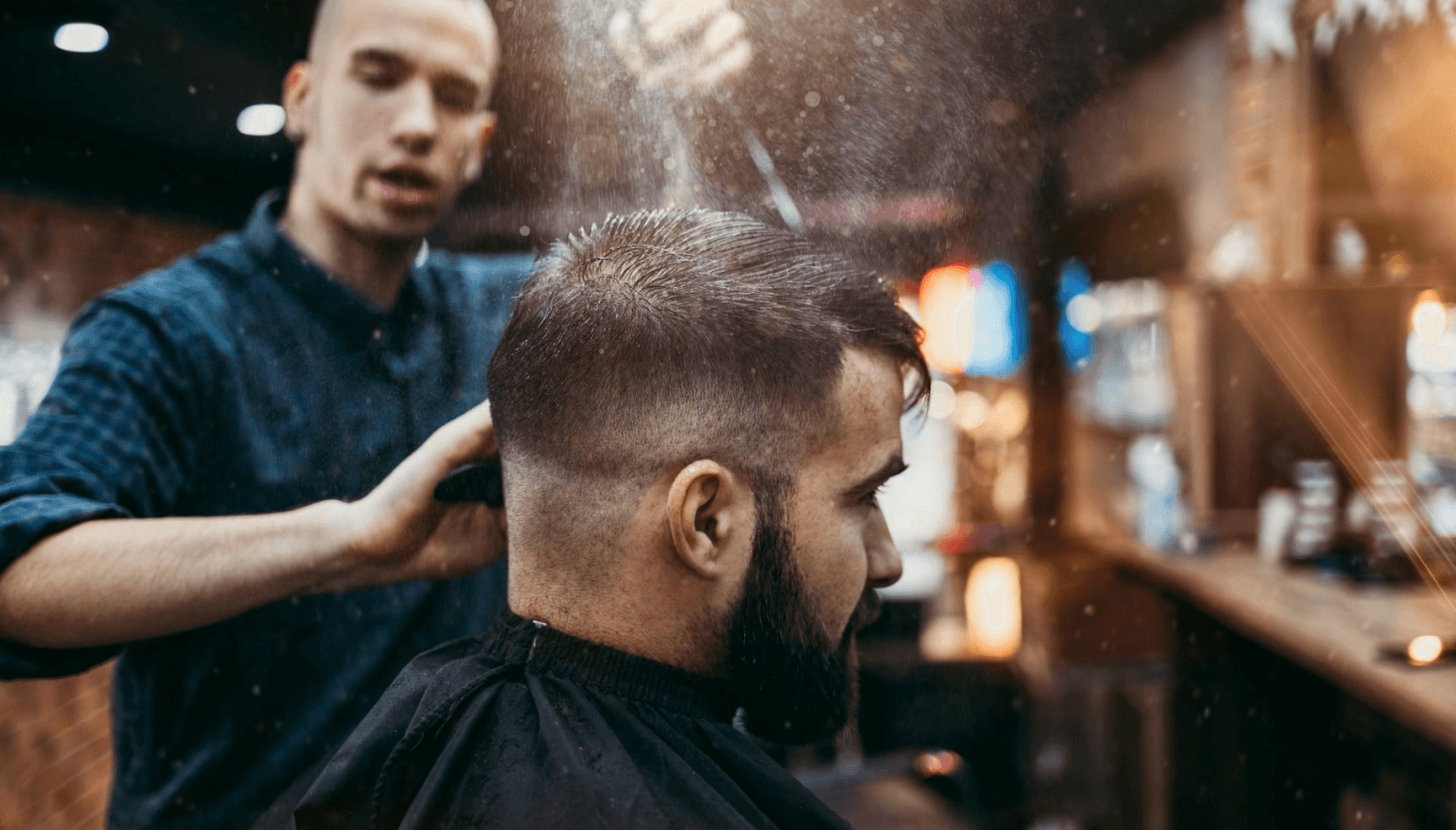 A stylist with a client at a barbershop - salon suite rental