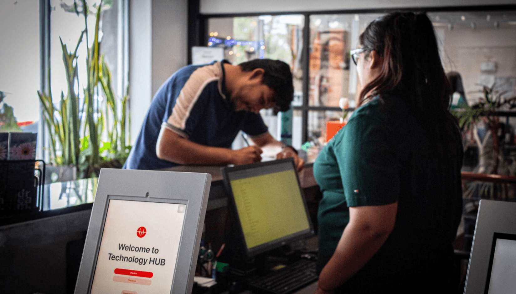 Visitor management check-in tablet at a coworking space reception desk